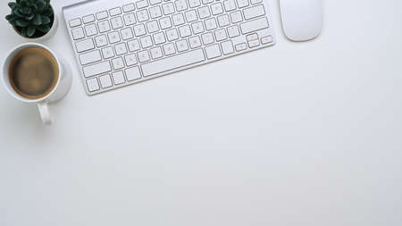 Female workplace with mobile phone notebook, coffee cup and office supplies on pink background.