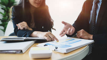 Two successful businesspeople  analyzing investment charts in modern office.