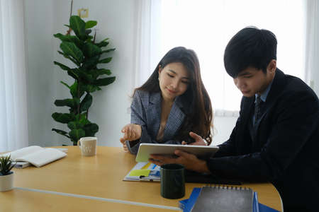 Two successful businesspeople  analyzing investment charts in modern office.