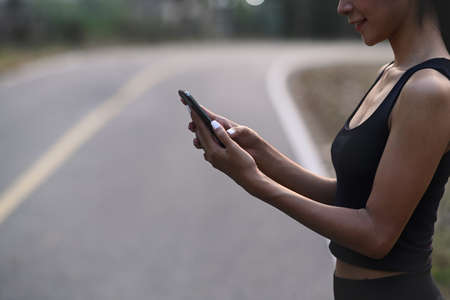 Shot of young woman stretching in the park and warming up in sunset time.