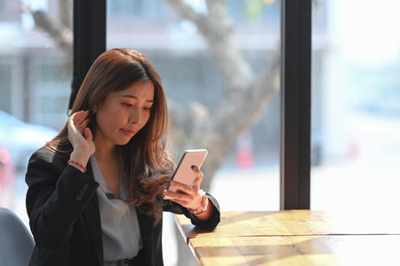 Young woman using computer laptop internet surfing in coffee shop.の写真素材