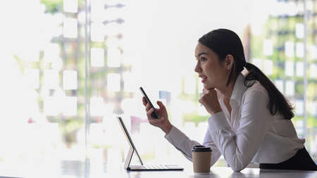 Businesswoman working with laptop computer and looking information on digital tablet.
