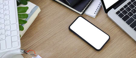 Top view of mock up computer laptop, headphone, coffee cup notebook, pens and plant on wooden table.の写真素材