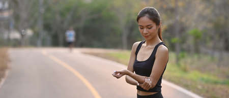 Rear view of sporty woman warming up before outdoor workout.の写真素材