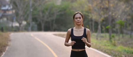 Rear view of sporty woman warming up before outdoor workout.の写真素材