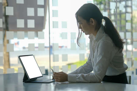 Portrait of attractive businesswoman holding credit card and and smiling to camera.の写真素材