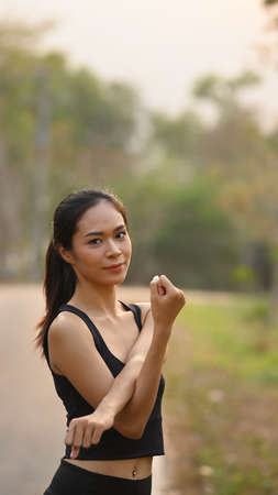 Rear view of sporty woman warming up before outdoor workout.の写真素材