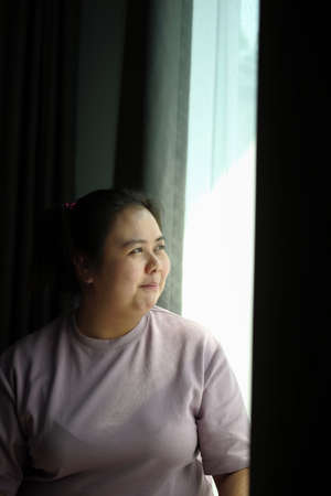 Close up view of obese woman  holding mock up smart phone and siting on sofa.