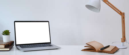 Computer tablet with blank screen, smart phone and stationery on female workplace.