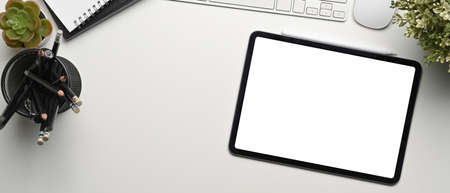 Above view of stylish workspace with keyboard, notebook, glasses and copy space on dark blue background.の写真素材