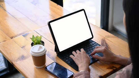 Two businesswoman colleagues using digital tablet searching for business data online in office.