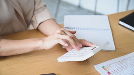 Two businesswoman colleagues using digital tablet searching for business data online in office.