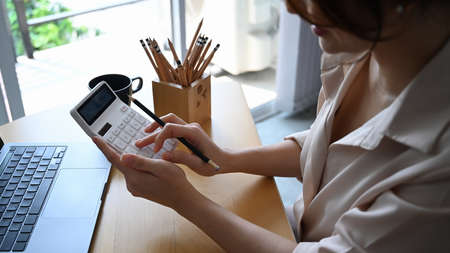 Above view of young woman office worker working with digital tablet on wooden office desk.の写真素材