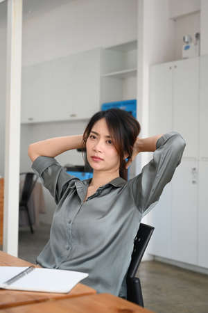 Portrait of young woman designer relaxing at her workplace.の写真素材