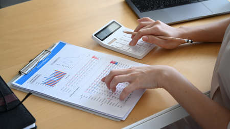 Above view of young woman office worker working with digital tablet on wooden office desk.の写真素材