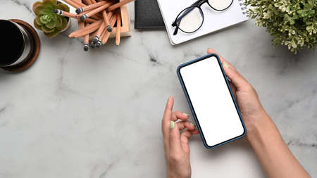 Female workplace with smart phone, glasses, notebook, wallet and stationery on white background.