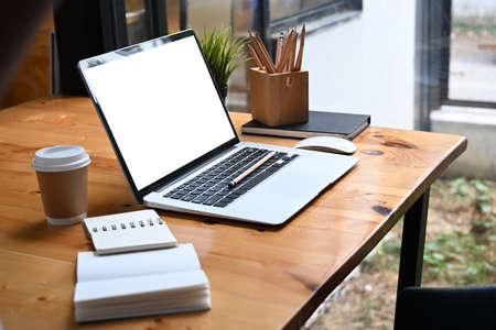 Cropped shot of businesswoman wearing earphone and working on computer tablet at office.