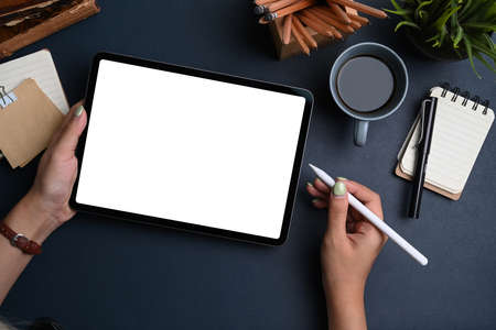 Top view of creative workplace with headphone, sticky notes, keyboard and copy space on green background.の写真素材