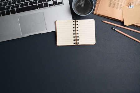 Top view of computer laptop, notebook, sticky notes and coffee cup on dark blue leather.の写真素材