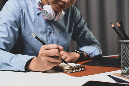 Young man lying on sofa and surfing internet on laptop computer at home.の写真素材