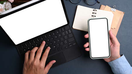 Top view of computer laptop, notebook, sticky notes and coffee cup on dark blue leather.の写真素材