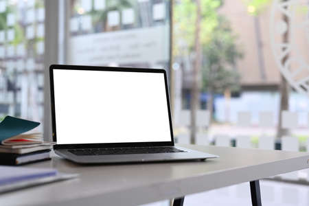 Comfortable workplace with computer laptop, coffee cup, house plant, book and pencil holder on white...