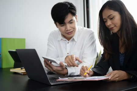 Businesspeople analyzing financial reports together in office.の写真素材