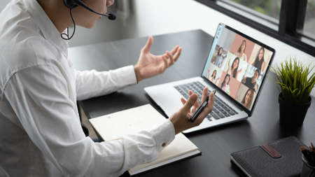 Cropped shot of businessman talking with diverse colleague team in video conference on computer...