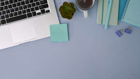Modern workplace near window with computer laptop, plant, notebook and headphone on black wooden table.の写真素材
