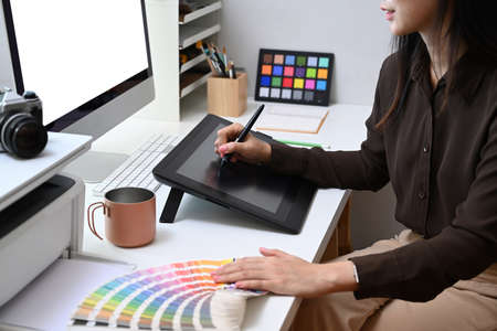 Smiling businesswoman sitting at outdoor and working with computer laptop and looking information on notebook.の写真素材