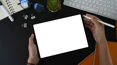 Top view of mock up digital tablet, stylus pen, notebook, coffee cup and sticky note on brown...