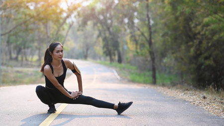 Rear view of sporty woman running in the evening with sunset.