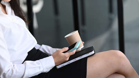 Side view of sportswoman stretching legs before workout outdoor.
