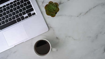 Top view of digital tablet with white screen, stylus pen, coffee cup and notebook on blue background.の写真素材
