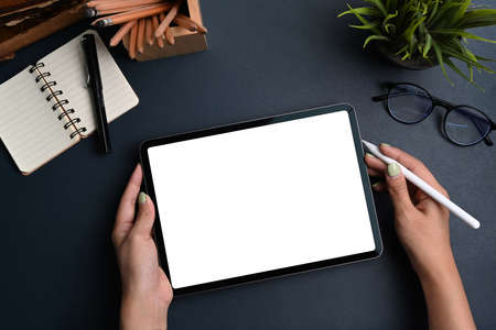 Mock up image of woman holding mobile phone with white screen while sitting on comfortable chair.の写真素材