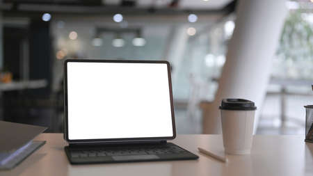 Above view of laptop computer, coffee cup and notebook on marble background.