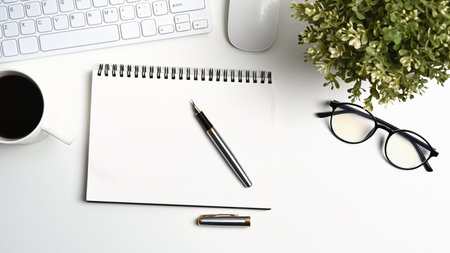 Empty picture frame and office supplies on white table at home office.