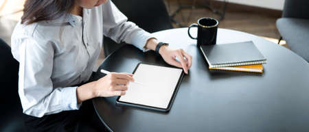 Happy young businesswoman sitting in modern office and talking on mobile phone.
