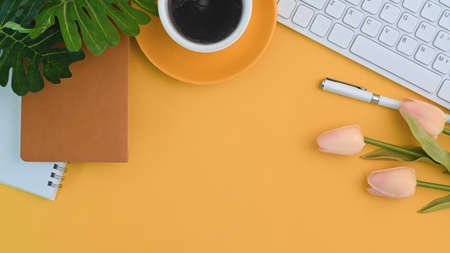 Modern workspace with computer laptop, coffee cup, notebook, smart phone and copy space on yellow background.の写真素材