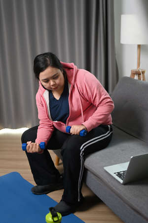 Obese woman tying shoelace preparing for exercises at home. Health and want to lose weight concept.