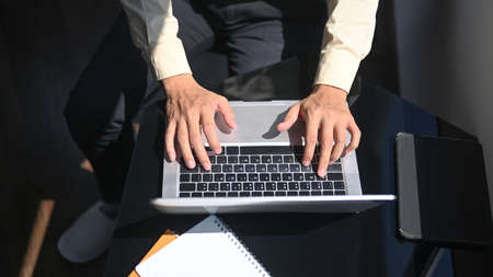 Top view workspace with empty screen of mobile phone and office supplies on white office desk.