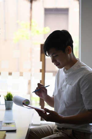 Portrait of calm businessman analyzing financial data at his office.の写真素材
