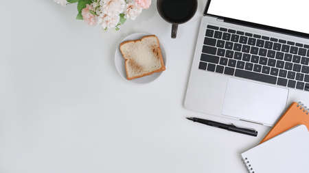 Mock up computer tablet with blank screen, coffee cup and supplies on white desk.