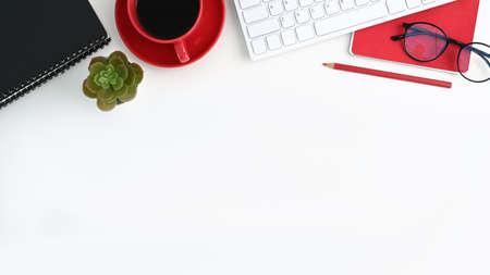 Modern workspace with computer, smart phone, and office supplies on white table.の写真素材