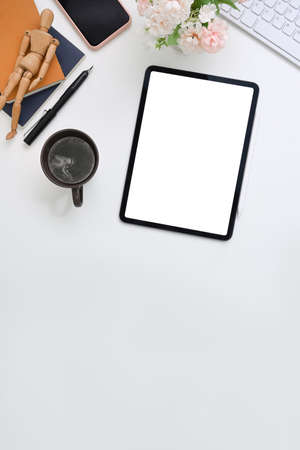 Stylish workspace with smart phone, laptop, notebook, glasses and flowers on orange background.の写真素材