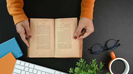 Stylish workspace with smart phone, laptop, notebook, glasses and flowers on orange background.の写真素材