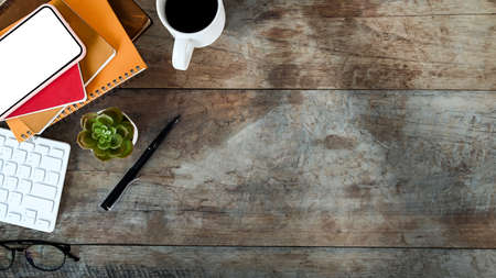 Top view modern workspace with digital tablet, laptop, coffee cup and notebook on blue leather.