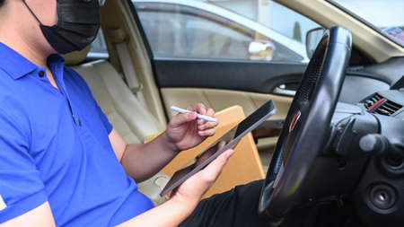 Close up view of businessman holding stylus pen and using digital tablet with his friend on sofa.