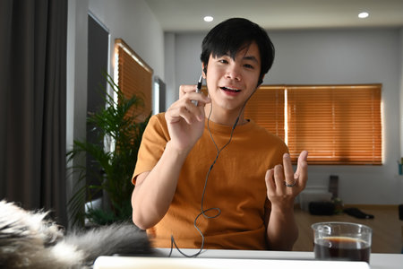 Happy casual man freelancer using laptop while sitting on sofa.