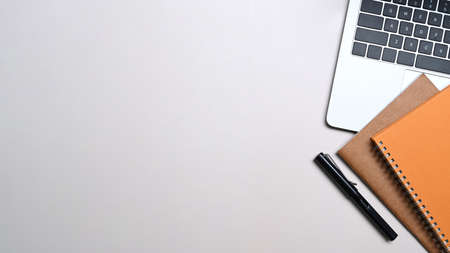 Female hands holding horizontal mobile phone on white table.